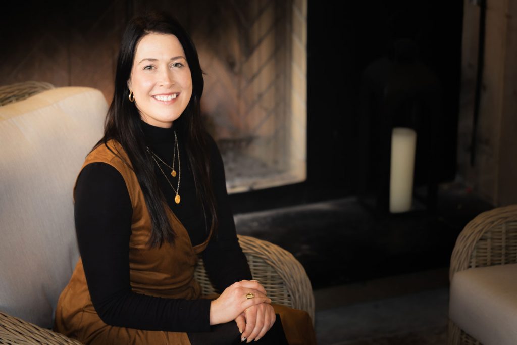 Bryanne Buckmuller seated by main fireplace