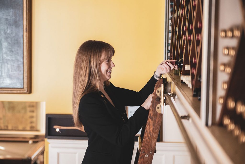 Emily Kirsch retrieving a bottle of wine