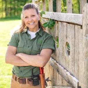 Nicole Bom stands in uniform by a gate