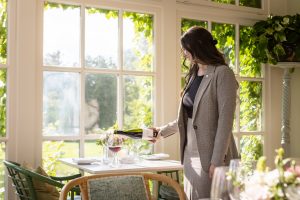 Esther pouring a glass of wine