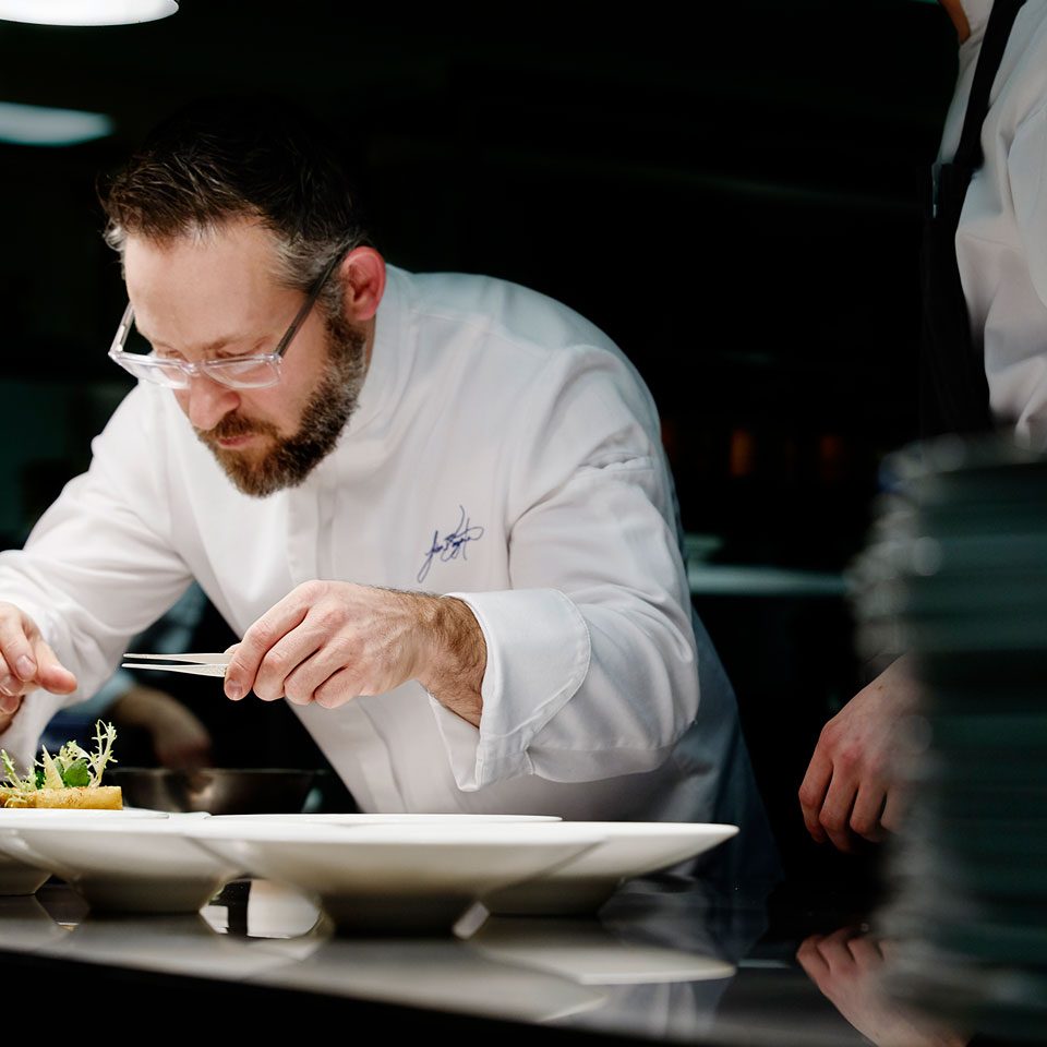 Executive Chef Jason Bangerter plating dinner for a guest